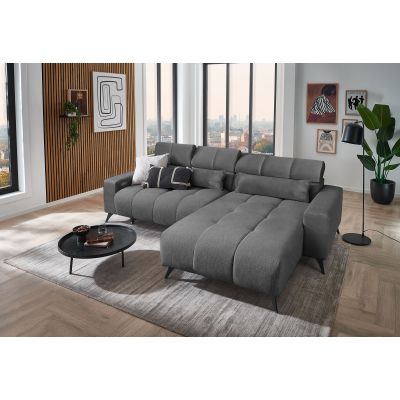 Dunkelgraues Ecksofa mit Ottomane rechts, verstellbaren Kopfstützen und Dekokissen in einem modern eingerichteten Wohnzimmer