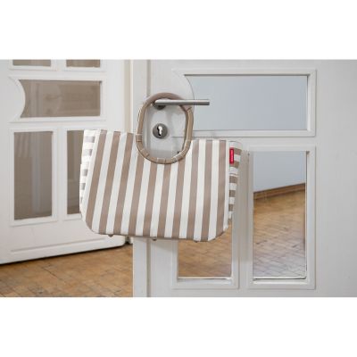 Gestreifte Reisenthel Tasche in Beige und Weiß aufgehängt an einer Tür