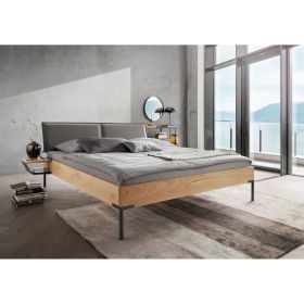 Bett mit gepolstertem Kopfteil und Holzrahmen in einem hellen Schlafzimmer mit Fensterfront und Nachttisch