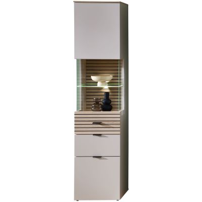 Eine hohe Vitrine mit geschlossenen Fronten oben und unten. In der Mitte befindet sich ein offenes, beleuchtetes Glasfach vor lamellenartiger Rückwand mit dekorierten Objekten.