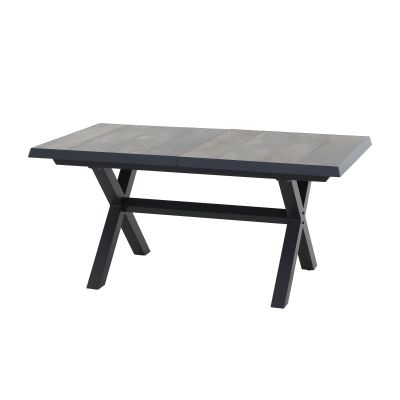 Ein rechteckiger Esstisch mit grauer Holzplatte und schwarzem X-förmigem Metallgestell, leicht schräg von vorne fotografiert.