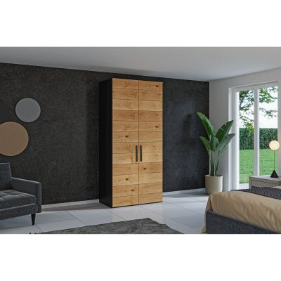 Schmaler Drehtürenschrank in einem eingerichteten Schlafzimmer an einer Wand stehend