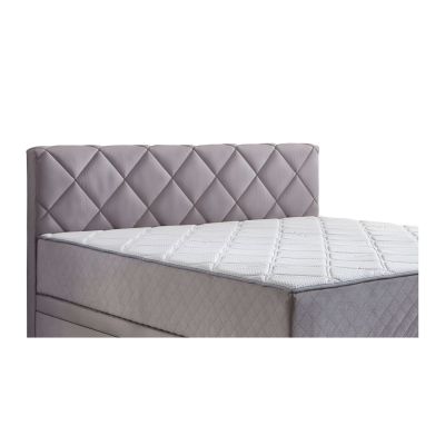Nahaufnahme eines fest vernähten Matratzentoppers auf einem Boxspringbett