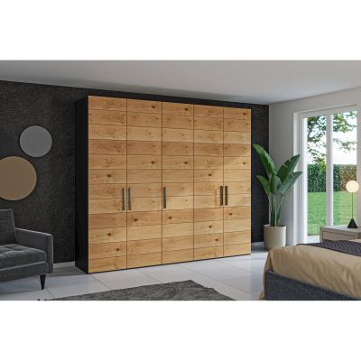 Drehtürenschrank in einem eingerichteten Schlafzimmer an einer Wand stehend