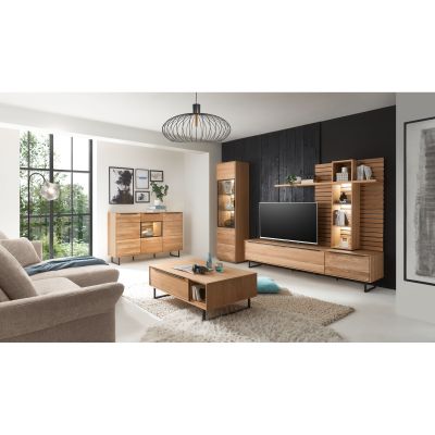 Eingerichtetes Wohnzimmer mit Möbeln der Serie Musterring Set One Jackson in Eiche teilmassiv. Die Wohnwand besteht aus Lowboard und beleuchtetem Aufsatzpaneel; zusätzlich sind Vitrine, Sideboard und Couchtisch zu sehen.