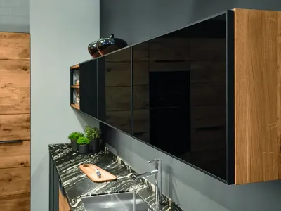 Hängeschränke aus Massivholz mit schwarzen Glasfronten in der Decker Küche Calezzo.
