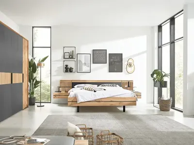 Helles Schlafzimmer mit Doppelbett, hellgrauem Teppich sowie modernen Möbeln in Anthrazit, Grau und hellem Holz