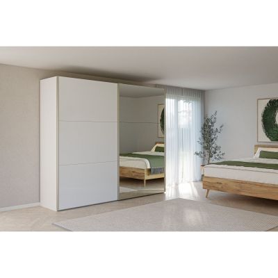 Schwebetürenschrank mit Spiegel in einem hellen Schlafzimmer neben einem Doppelbett