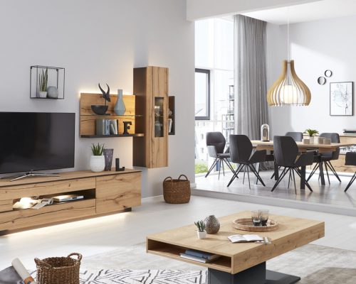 Modernes Wohnzimmer mit Holzmöbeln, Fernseher und Essbereich. Neutrale Töne, große Fenster und stilvolle Dekorelemente.