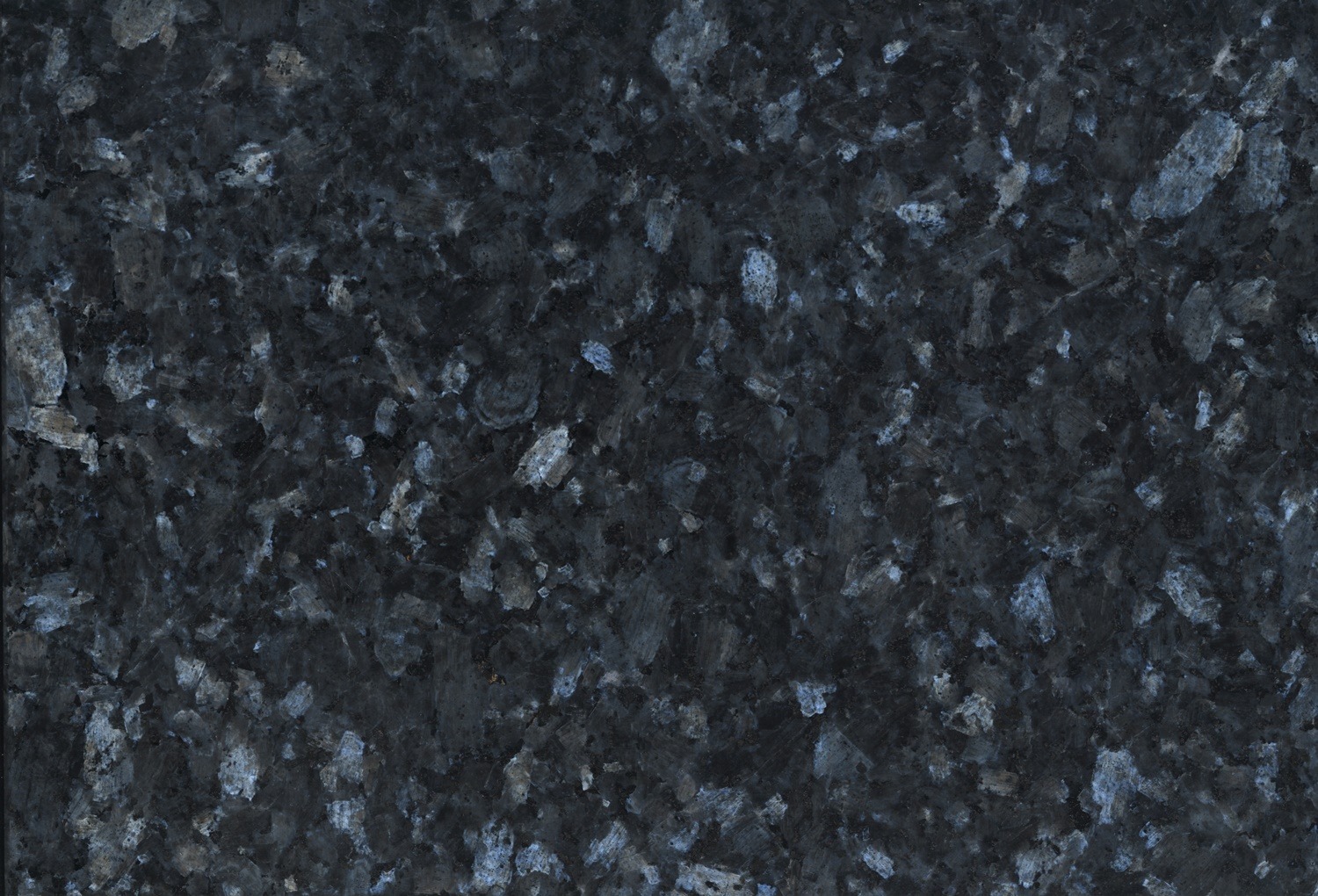 Nahaufnahme von dunklem Granit mit blauen und grauen Sprenkeln, die eine strukturierte Steinoberfläche zeigt.