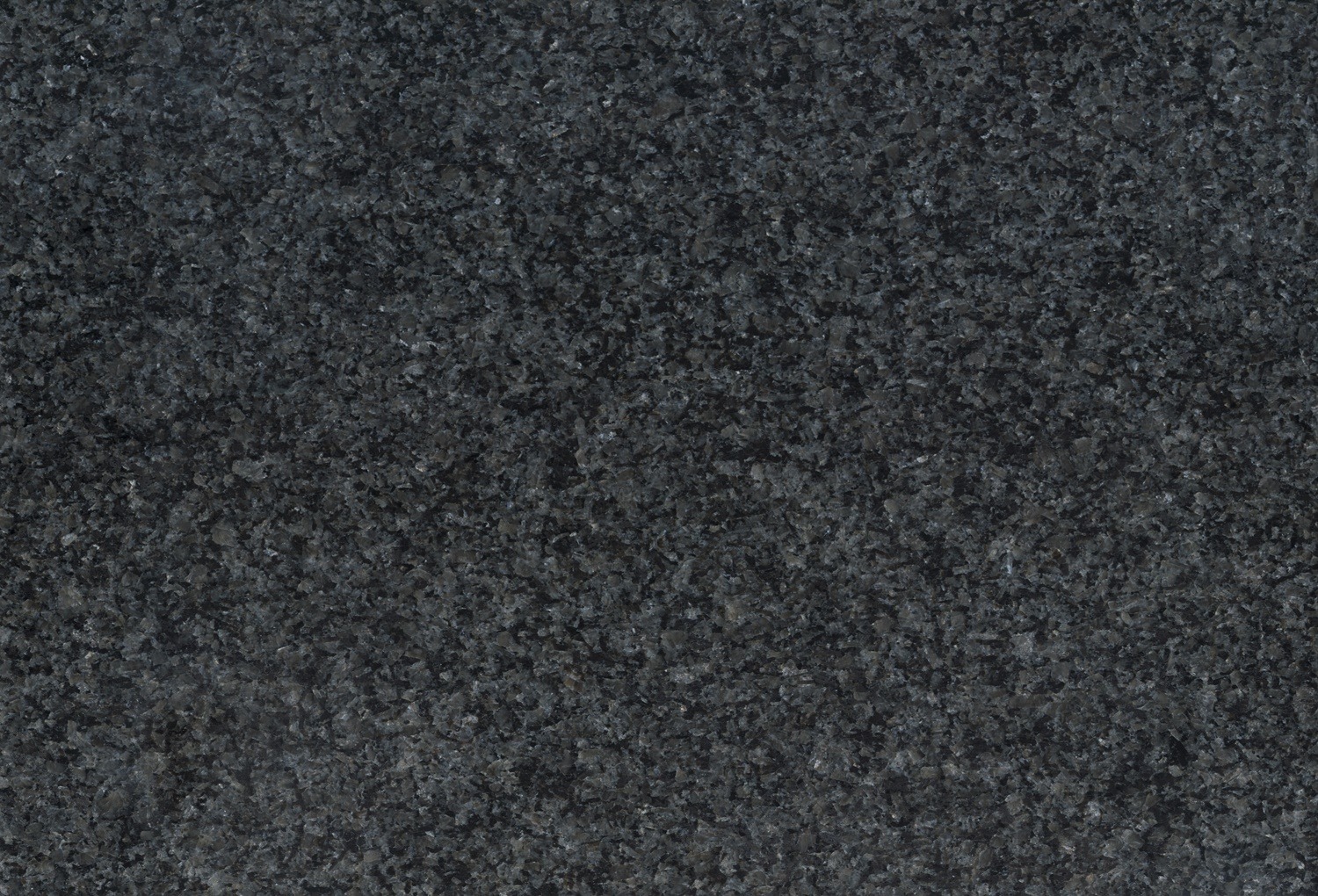 Die dunkle strukturierte Granitoberfläche von Möbel Gruber weist ein gesprenkeltes Muster in Grau- und Schwarztönen auf.