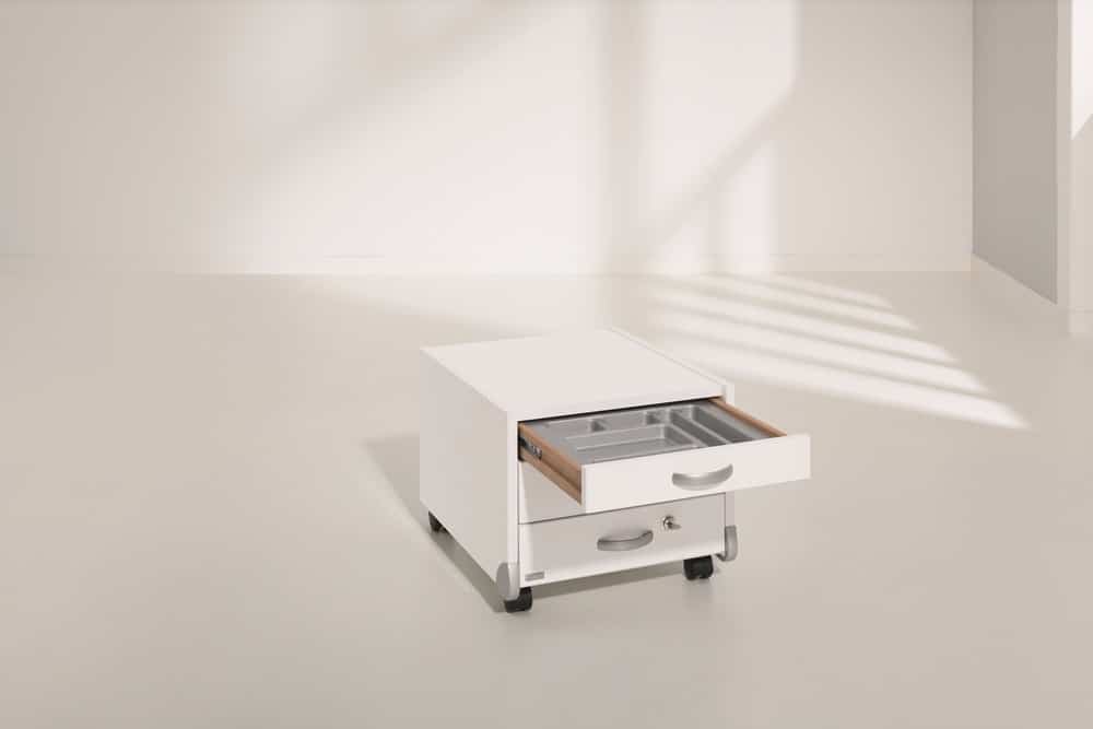 Ein weißer Rollschrank von Möbel Gruber mit offener Schublade steht auf hellem Boden in einem gut beleuchteten, minimalistischen Raum.