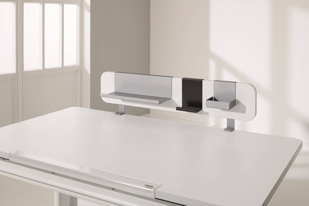 Minimalistischer weißer Schreibtisch von Möbel Gruber mit Regal darüber, kleinen Fächern und natürlichem Licht durch ein Fenster.