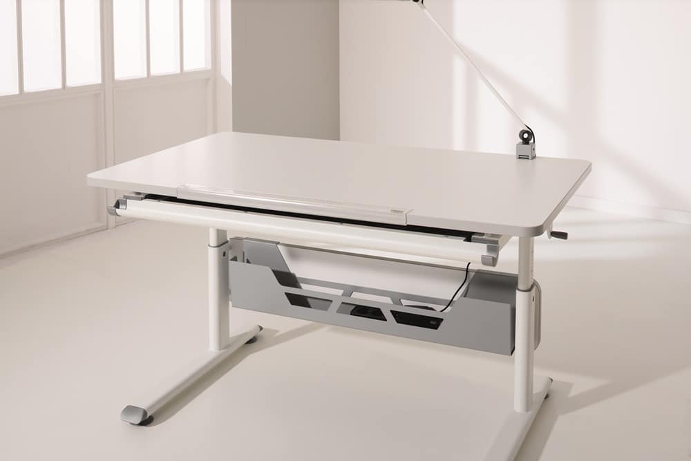 Moderner, höhenverstellbarer Schreibtisch von Möbel Gruber mit schlankem Design, integriertem Kabelmanagement und angeschlossener Lampe.
