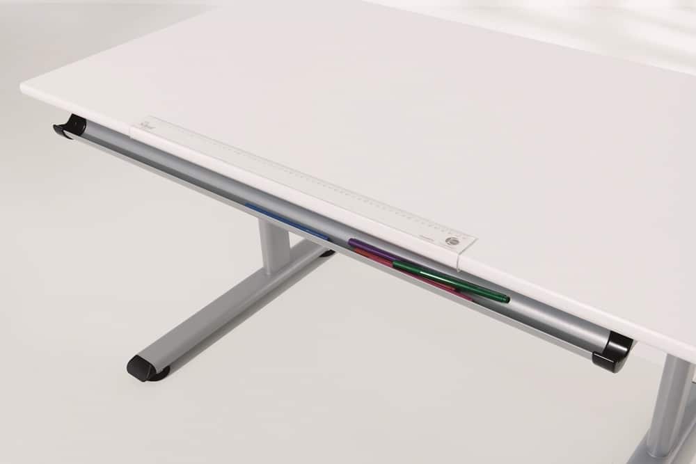 Weißer Schreibtisch von Möbel Gruber mit einem Metallrahmen, unter dem sich ein Lineal sowie bunte Stifte und Bleistifte befinden.