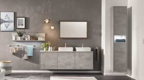 Modernes Badezimmer mit Doppelwaschbecken, grauen Schwebeschränken von Möbel Gruber, Wandkunst und Regalen mit Pflanzen und Handtüchern.