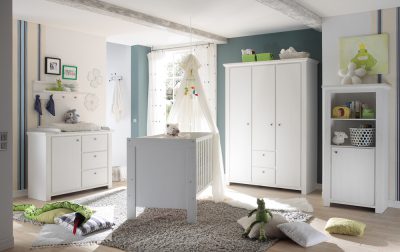 Ein helles Kinderzimmer mit Babyzimmermöbeln, einem Kinderbett, Spielzeug, grünen Akzenten, weichem Teppich und natürlichem Licht durch ein Fenster.