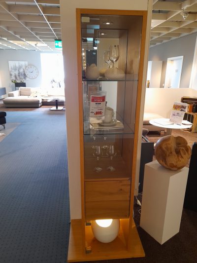 Vitrine von Möbel Gruber: Eine Vitrine aus Holz mit Glasböden zur Präsentation von Gläsern und Dekor im Ausstellungsraum.