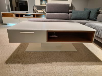 Interliving Couchtisch von Möbel Gruber, mit Schublade und offenem Regal auf beigem Teppich in stylischem Wohnzimmerambiente.