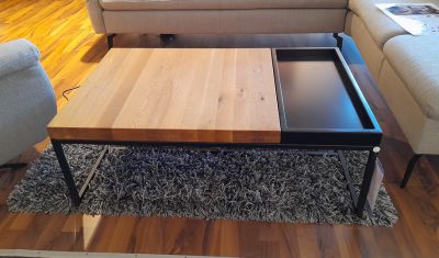 Bild von einem braunen Couchtisch mit schwarzer Platte und schwarzen Beinen