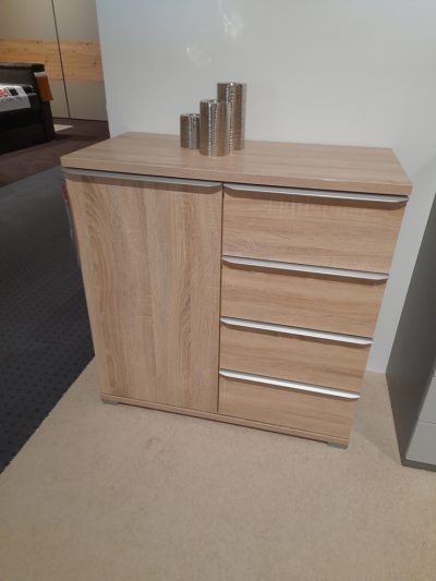 Eine Kombikommode von Möbel Gruber aus Holz mit drei Schubladen und einem Seitenschrank hat oben metallische Kerzenhalter.