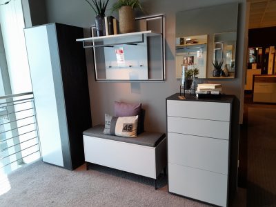 Interliving Garderobe bietet moderne Möbel: eine Bank, einen hohen Schrank, eine Kommode, Spiegel und dekorative Pflanzen.