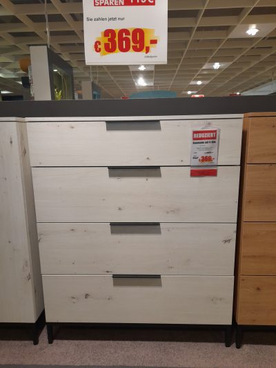 Bei Möbel Gruber gibt es die Kommode „Kommode“ aus hellem Holz für 369 Euro im Angebot, darüber ein rot-gelbes Rabattschild.