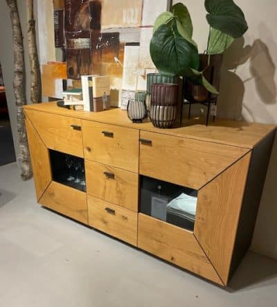 Interliving Sideboard mit Schubladen und Schränken, dekoriert mit Pflanzen auf hellem Boden.
