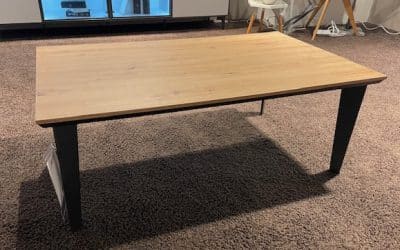 Bild von einem braunen Couchtisch mit schwarzen Beinen