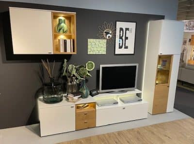 Modernes Wohnzimmer mit Schöner Wohnen Wohnwand, Wandschränken, Dekoartikeln und einem Flachbildfernseher.