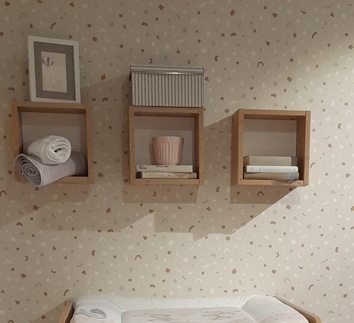 Foto von drei viereckigen braunen Regalen an der Wand hängen