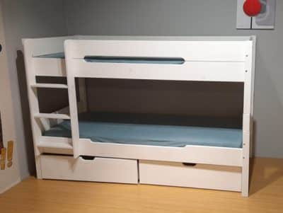 Foto von einem weißen Kinderhochbett mit Leiter. Unter dem Bett sind zwei Schubladen
